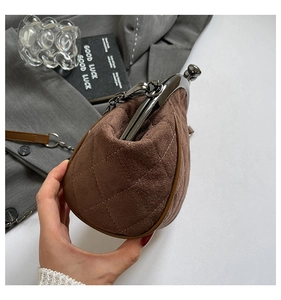 Close-up of brown quilted suede shell bag with vintage metal clasp and chain strap