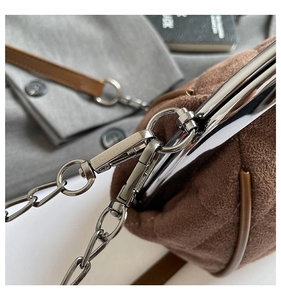 Detail of vintage metal clasp and brown suede texture on luxury chain crossbody bag