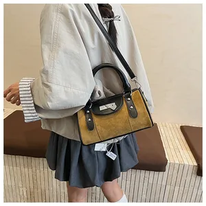 Détail du sac Boston en daim vintage avec serrure en métal coeur et rivets renforcés
