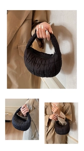 Detail of black quilted cloud bag with padded texture and crescent moon silhouette