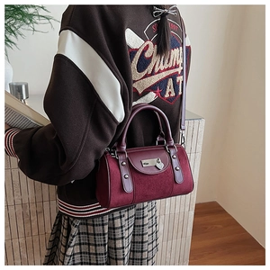 Détails du sac Boston bordeaux en daim avec pendentif coeur et bandoulière en cuir