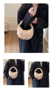 Detail of beige quilted crescent bag featuring soft padded texture and top handle