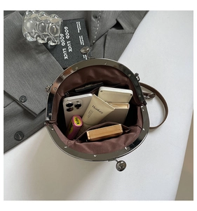 Internal view of the retro shell bag showing a phone and cosmetics in spacious compartments