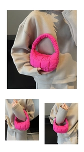 Detailed view of magenta quilted puffer bag with padded handle and soft textured fabric