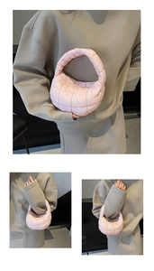 Detail of light pink quilted cloud bag with padded pleated texture and soft top handle