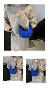Close-up of electric blue quilted puffy handbag featuring soft square padded texture