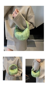 Detail showing pleated light green quilted cloud bag worn as a stylish underarm bag