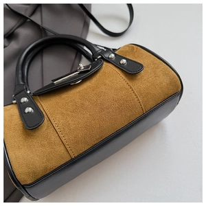 Détail du sac Boston en daim vintage avec texture marron et rivets métalliques argentés
