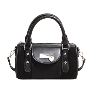 Détail du sac Boston noir en daim montrant l'anse et le pendentif cœur en métal