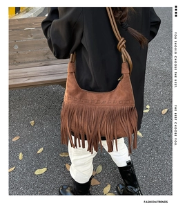 Détail du sac hobo en daim marron avec de longues franges bohèmes et une bandoulière nouée