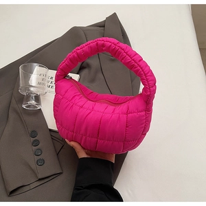 Close-up of fuchsia quilted puffer handbag with ruched handle and diamond stitching