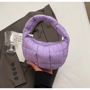 Close-up of lavender quilted handbag with soft puffy texture and silver metal zipper