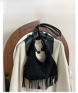 Détail du sac à bandoulière en daim noir avec de longues franges et une finition mate