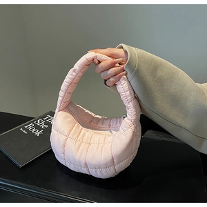 Detail of light pink quilted cloud bag featuring soft crescent shape and square textures