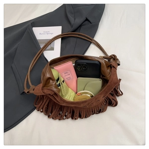 Détail du sac hobo en daim marron montrant l'intérieur spacieux et les franges bohèmes