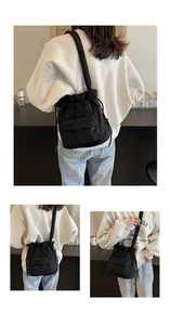 Detail of quilted black nylon bucket bag with drawstring and front flap pocket on a model