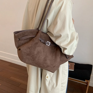 Braune Shopper-Tasche aus Wildlederimitat mit Metallschnalle an einem Model getragen
