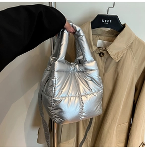 Detail of silver quilted padded handbag with metallic finish and soft square texture
