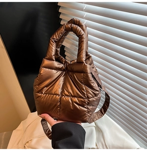Detailed macro view of bronze quilted metallic nylon texture on puffer handbag