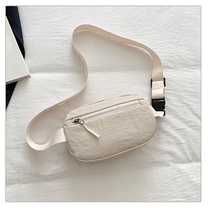 Top view of beige nylon crossbody bag with zipper pocket and black buckle details