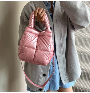 Detail of pink quilted puffer bag showing soft padded texture and metallic finish