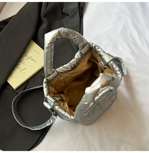 Detailed view of silver quilted tote bag with metallic finish, interior zip pocket and magnetic clasp