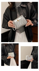 Macro detail of silver woven texture wallet featuring a golden camellia flower clasp