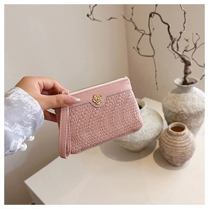 Pink textured leather wallet with rose-shaped metal clasp and matching wrist strap