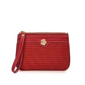 Detail of dark red faux leather coin purse with horizontal stripes and golden flower charm