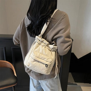 Minimalist beige nylon bucket bag with drawstring closure and shoulder strap for women