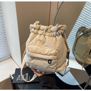 Minimalist beige nylon bucket bag with quilted texture and drawstring closure