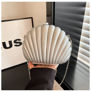 Detail of shell-shaped acrylic clutch bag with matte silver texture and chain strap