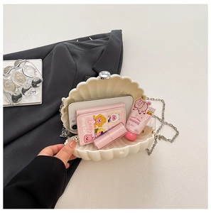 Internal view of shell acrylic clutch bag showing storage space for phone and makeup