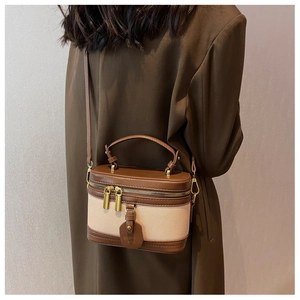 Dettaglio borsa a scatola vintage in pelle marrone e tela beige con cuciture a contrasto