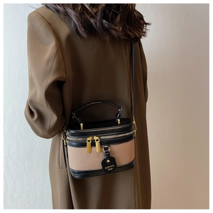 Détail du sac seau vintage avec tissu bicolore, accents en cuir et finitions dorées