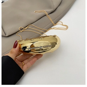 Detailed side view of a heart-shaped gold metallic clutch with chain and metal hinge