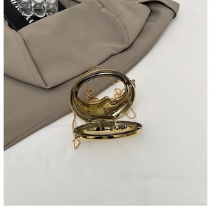 Detailed view of clear mini evening bag with gold metal frame and detachable chain strap