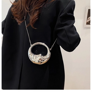 Silver lunar texture mini ball bag with metal chain shown on black blazer shoulder