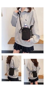 Detail view of black nylon crossbody bag used as a water bottle holder for outdoor sports