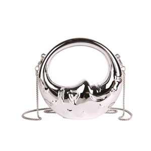 Close-up of silver moon face evening bag with metallic mirror finish and chain strap