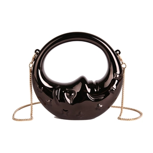 Detail of crescent moon mini bag in glossy black with star and moon face embossing