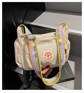 Detailed shot of beige nylon crossbody bag with colorful Suchao embroidered strap