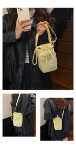 Detailed views of light yellow nylon drawstring bucket bag with adjustable strap and front pocket