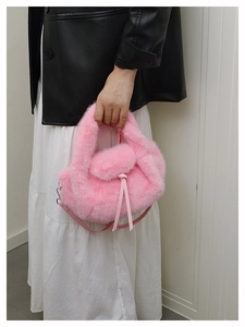 Detailed view of pink faux fur crossbody bag with leather drawstring and slim strap