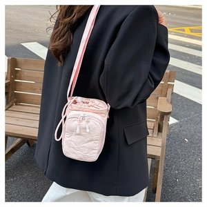 Pink pleated crossbody bag detail showing drawstring closure and outdoor lifestyle usage