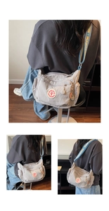 Detail of light grey nylon crossbody bag with multi-zipper layers and colorful strap
