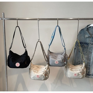 Close-up of waterproof nylon crossbody bags with multi-zipper pockets and wide logo straps