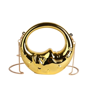 Macro shot of gold moon-shaped evening bag with metallic finish and delicate chain strap