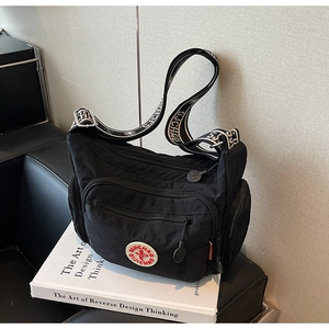 Detailed view of the multi-pocket black nylon crossbody bag with jacquard shoulder strap