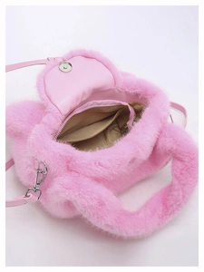 Detail of pink fluffy bag interior featuring brown lining, zipper pocket and magnetic buckle